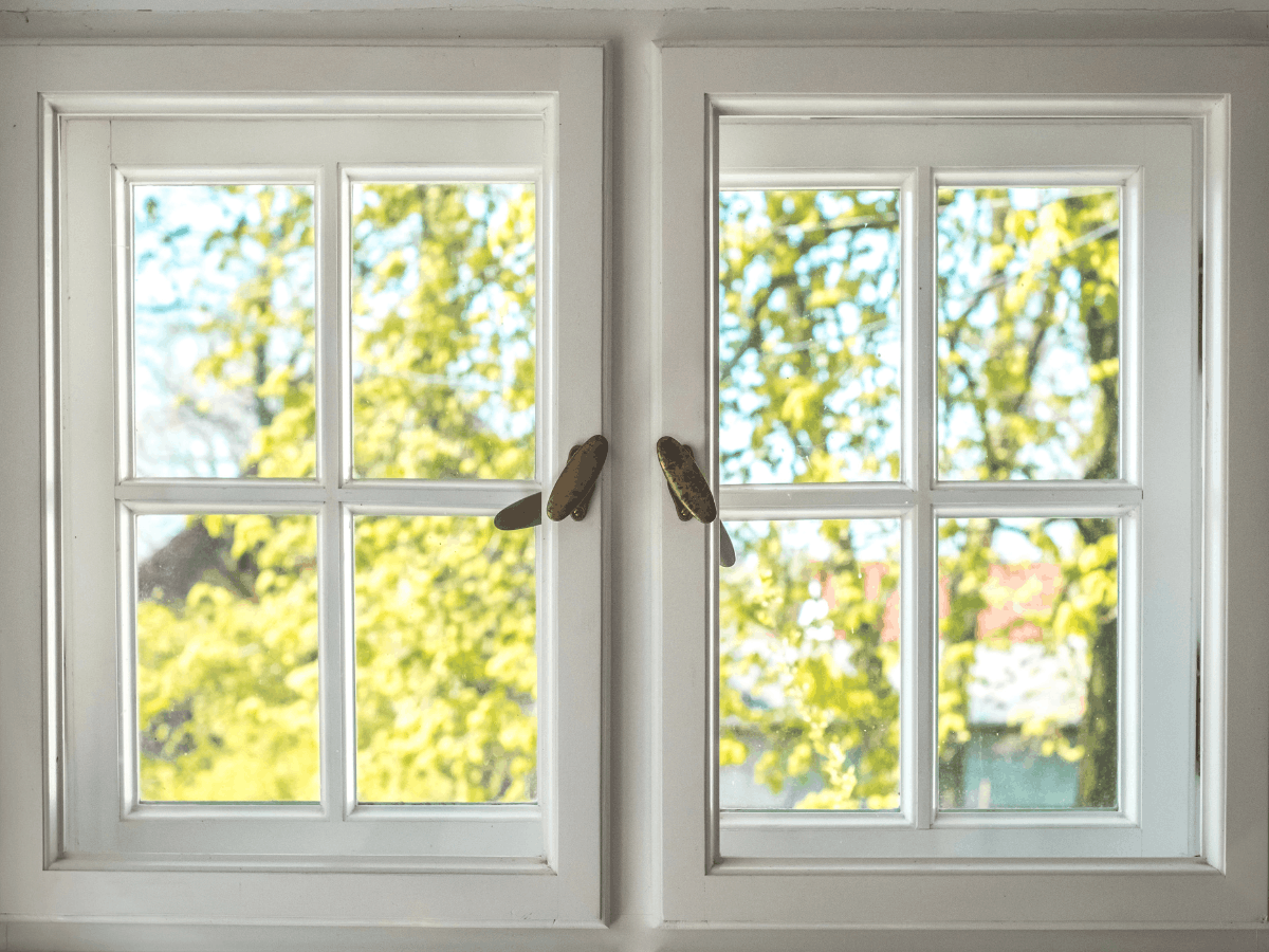 Pair of white casement windows with brass handles