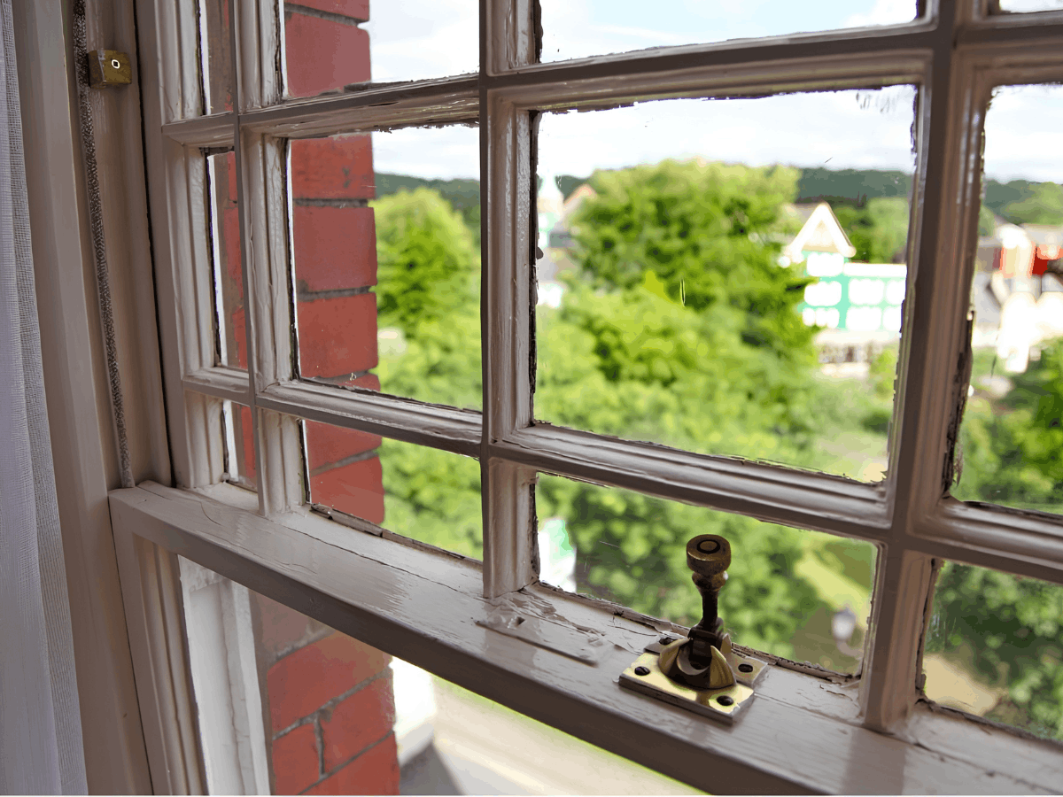 Sash window with brass lock on a painted timber frame