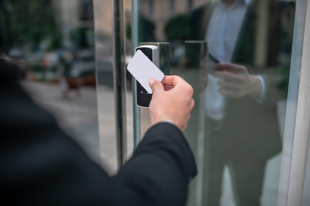 Person using keycard to get the front door of a business.