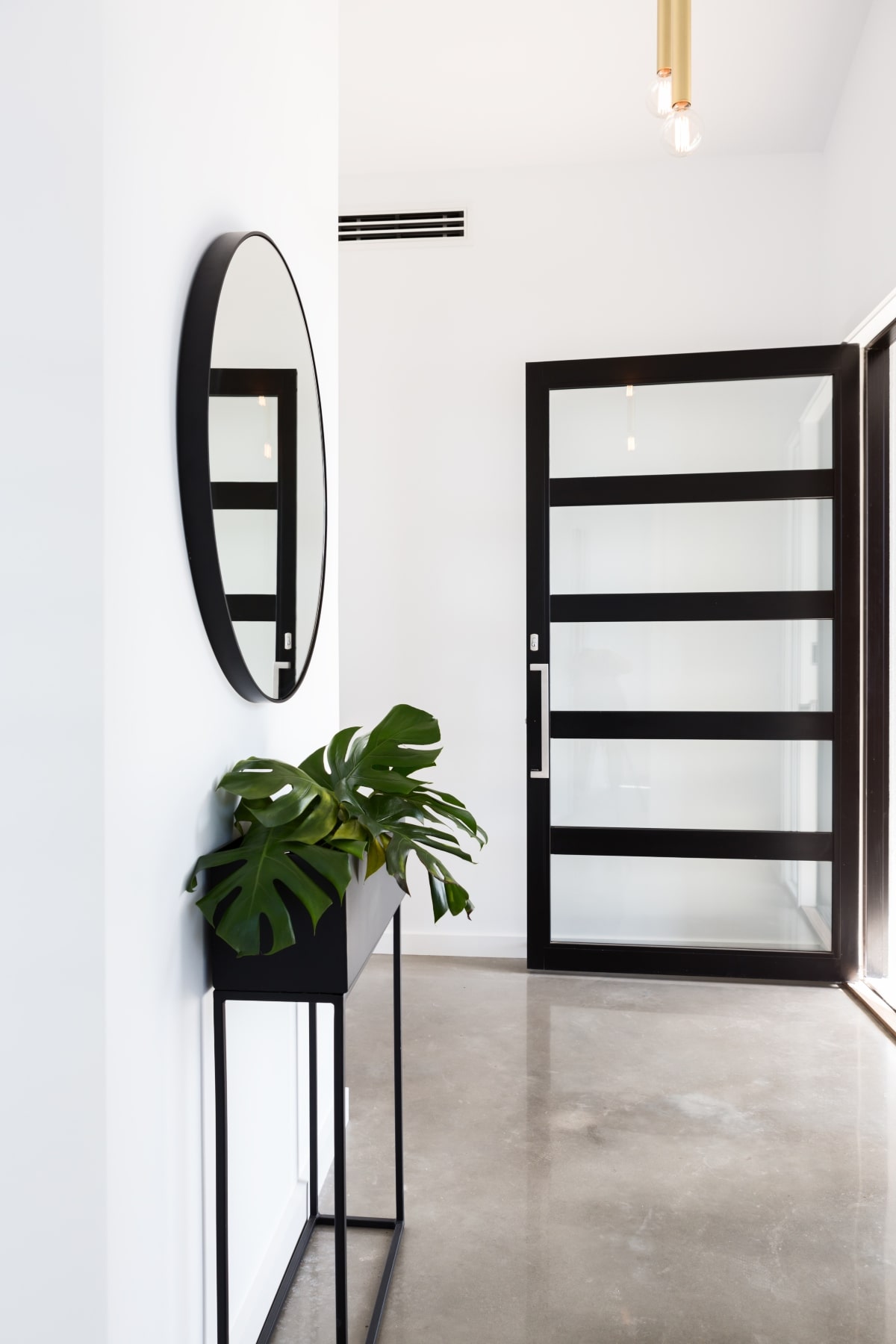 A house entrance with a contemporary black and glass door.